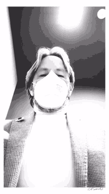 a black and white photo of a man wearing a n95 face mask