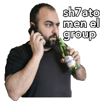 a man talking on a cell phone while holding a bottle of mazza