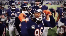 a group of football players are standing on a field and one of them is wearing a helmet with the letter c on it .