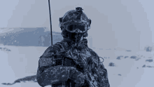 a soldier is standing in the snow holding a gun and wearing a helmet and goggles