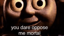 a close up of a thomas the tank engine face with a caption that says `` you dare oppose me mortal '' .