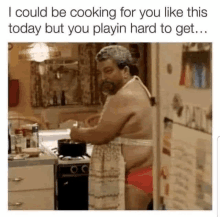 a man in an apron is cooking in a kitchen while wearing underwear .