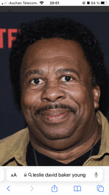 a phone screen shows a picture of a man named leslie david baker young