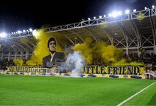 a soccer field with a banner that says little friend on it