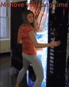 a woman standing in front of a vending machine that says " me love you long time " on it