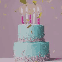 a birthday cake with candles and confetti falling on it