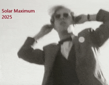 a black and white photo of a man in a suit with the words solar maximum 2025