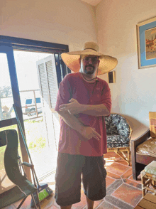 a man wearing a straw hat stands in a room