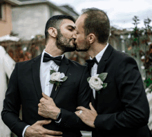 two men in tuxedos kissing with one wearing a watch