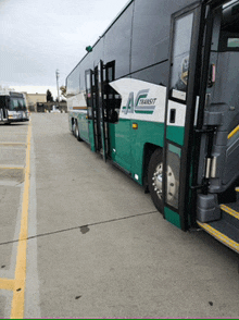 a green and white bus with a transit logo on the side