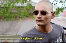 a bald man wearing sunglasses says " bujhis ni bhai " in yellow