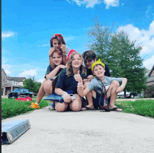 a group of children are posing for a picture on the sidewalk