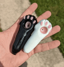 a person is holding a black and white paw print pipe