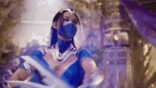 a woman in a blue costume and mask is holding a sword in her hand .