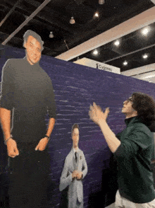 a man is standing in front of a cardboard cutout of a man