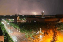 an aerial view of a city at night with a lightning strike in the sky .