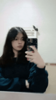 a girl is taking a selfie in a mirror with her phone .