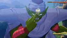 piccolo from dragon ball z is giving the middle finger while playing a video game .