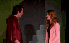 a man in a red robe is giving a woman a high five