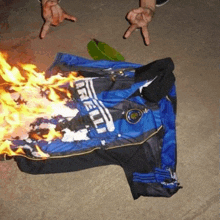 a person is standing next to a burning blue and black shirt .