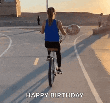 a woman is riding a bike while holding a balloon and the words happy birthday are written on the bottom