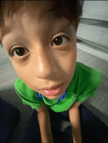 a young boy wearing a green shirt that says " i love you " on it