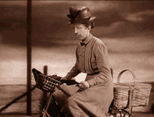 a woman in a straw hat is riding a bike with a basket