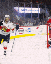 a hockey player wearing a florida panthers jersey stands on the ice in front of a glidden by ppg sign