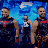 three wrestlers are standing in front of a sign that says ua