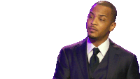 a man in a suit and tie stands in front of a white backdrop