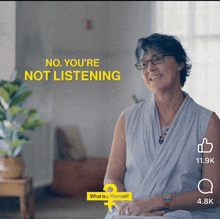 a woman is sitting in front of a yellow sign that says no you 're not listening