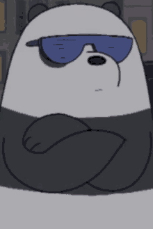 a panda bear wearing sunglasses and a hat is sitting down with his arms crossed .