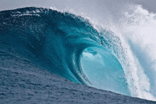 a large wave in the ocean is breaking over a cliff