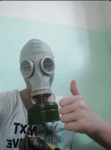 a person wearing a gas mask giving a thumbs up sign