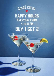 two martini glasses on a table with a sign that says happy hours everyday from 4 to 8pm