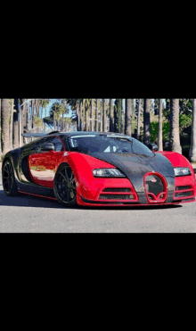 a red and black bugatti veyron is parked on a street