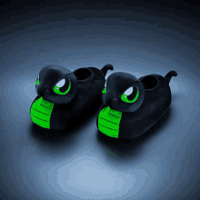 a pair of black slippers with green eyes and a green mouth