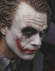 a close up of a man 's face with a joker makeup