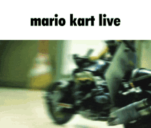 a blurred image of a person riding a motorcycle with the words mario kart live on the bottom