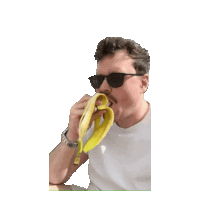 a man wearing sunglasses is eating a banana peel