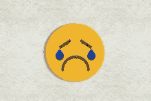 a yellow smiley face with blue tears on it 's eyes .