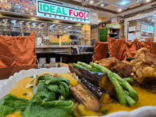 a plate of food in front of a sign for ideal food restaurant