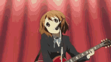 a girl in a school uniform is singing into a microphone while playing a guitar