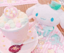 a cup of hot chocolate with marshmallows and a stuffed animal on top of it .