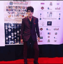 a man in a suit stands in front of a wall that says world film festival on it