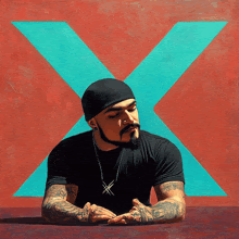 a man with a beard is sitting in front of an x on a red background