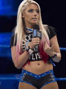 a female wrestler is holding a microphone in her hand