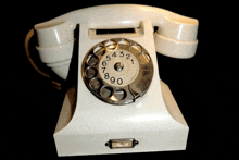 an old fashioned white telephone with the number 54321 on the dial