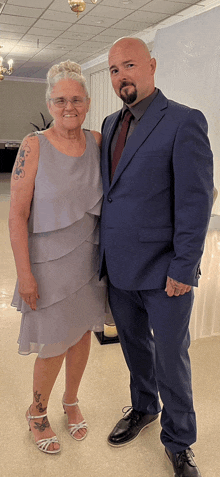 a man in a suit and a woman in a dress pose for a photo