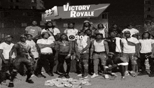 a group of young men are posing in front of a sign that says victory royale